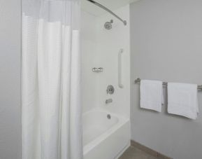 Guest bathroom with shower and tub at Courtyard By Marriott Tampa Oldsmar.