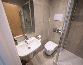 Guest bathroom with shower at Belgrave Oval London Hotel.