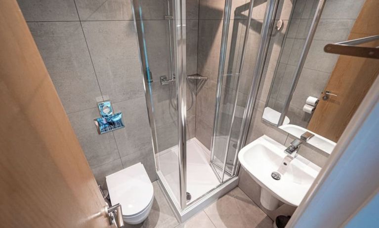 Private guest bathroom with shower at Belgrave Oval London Hotel.