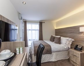 Day use room with work desk, TV screen, floor to ceiling window and coffee station at Hotel Shepherds Bush London.