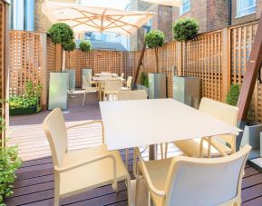 Beautiful outdoor patio with sitting area at Indigo London-Paddington Hotel.