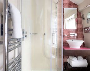 Private guest bathroom with shower and free toiletries at Indigo London-Paddington Hotel.