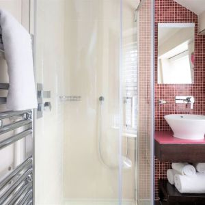 Private guest bathroom with shower and free toiletries at Indigo London-Paddington Hotel.