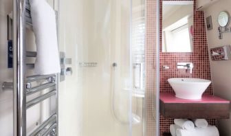 Private guest bathroom with shower and free toiletries at Indigo London-Paddington Hotel.