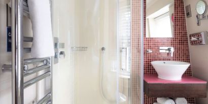 Private guest bathroom with shower and free toiletries at Indigo London-Paddington Hotel.