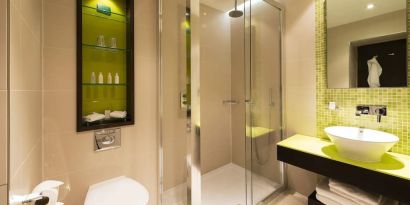 Guest bathroom with shower and free toiletries at Indigo London-Paddington Hotel.