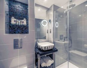 Guest bathroom with shower and free toiletries at Mercure London Hyde Park Hotel.