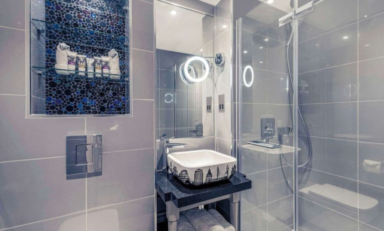 Guest bathroom with shower and free toiletries at Mercure London Hyde Park Hotel.