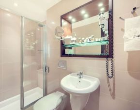 Private bathroom with tub and free toiletries at Mercure London Paddington Hotel.