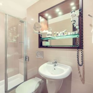 Private bathroom with tub and free toiletries at Mercure London Paddington Hotel.