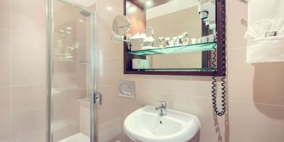 Private bathroom with tub and free toiletries at Mercure London Paddington Hotel.