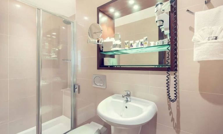 Private bathroom with tub and free toiletries at Mercure London Paddington Hotel.