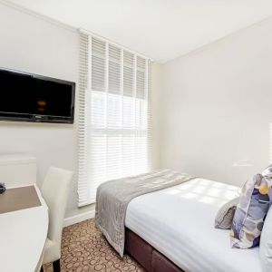 Bright day use room with TV screen, work desk and private bathroom at Mercure London Paddington Hotel.