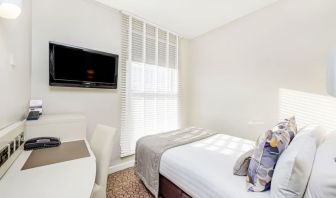 Bright day use room with TV screen, work desk and private bathroom at Mercure London Paddington Hotel.