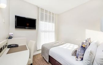 Bright day use room with TV screen, work desk and private bathroom at Mercure London Paddington Hotel.