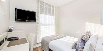 Bright day use room with TV screen, work desk and private bathroom at Mercure London Paddington Hotel.