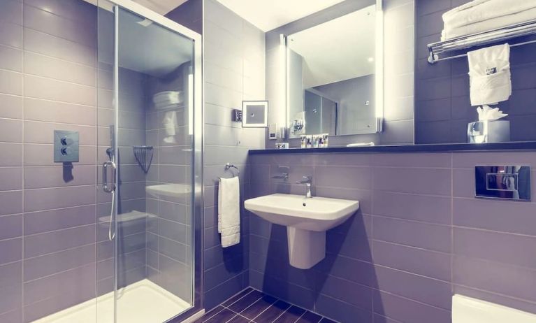 Guest bathroom with shower and free toiletries at Mercure London Paddington Hotel.