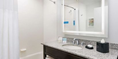 Guest bathroom with shower and tub at Hampton Inn Washington DC / White House.