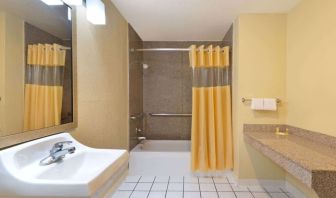 Guest bathroom with shower and tub at Days Inn By Wyndham San Antonio Northwest/Seaworld.