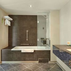 Guest bathroom with combined tub and shower at Hyatt Place London Heathrow Airport. 