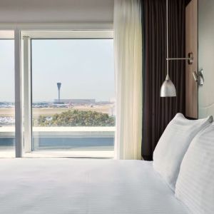 King bed with floor to ceiling window at Hyatt Place London Heathrow Airport.