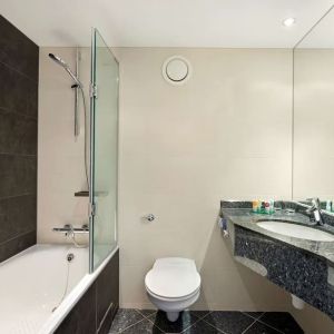 Private guest bathroom with combined tub/shower and free toiletries at Hyatt Place London Heathrow Airport.