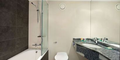 Private guest bathroom with combined tub/shower and free toiletries at Hyatt Place London Heathrow Airport.