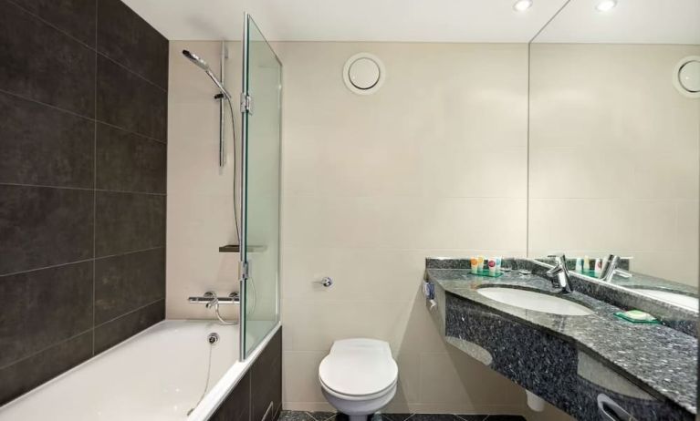 Private guest bathroom with combined tub/shower and free toiletries at Hyatt Place London Heathrow Airport.