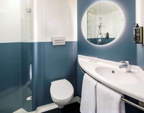 Private guest bathroom with shower and free toiletries at Ibis London Blackfriars Hotel.