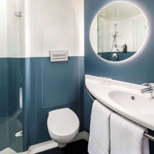 Private guest bathroom with shower and free toiletries at Ibis London Blackfriars Hotel.