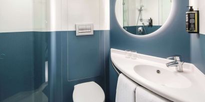 Private guest bathroom with shower and free toiletries at Ibis London Blackfriars Hotel.