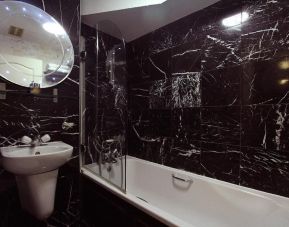 Guest bathroom with tub at Opulence Central London Hotel.