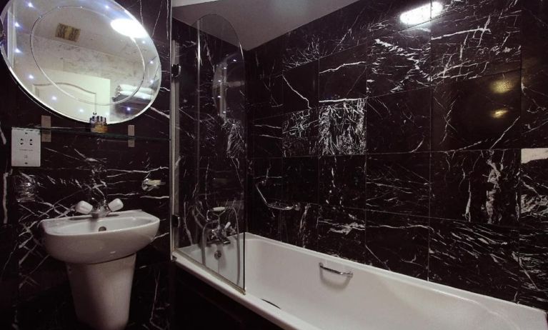 Guest bathroom with tub at Opulence Central London Hotel.