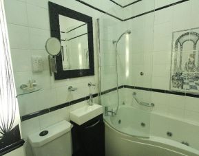 Private bathroom with tub and free toiletries at Opulence Central London Hotel.