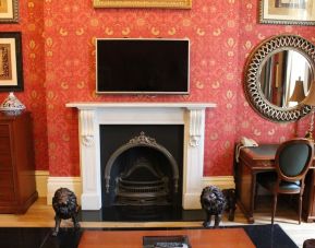 Day use senior suite's living area with fireplace and work desk at Opulence Central London Hotel.