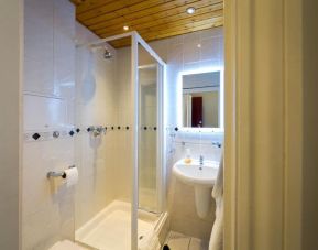 Guest bathroom with shower at Adria Hotel.