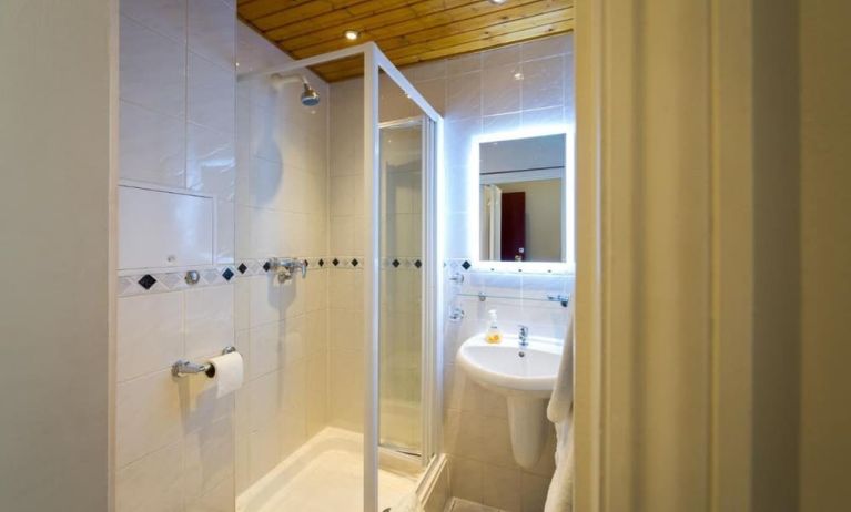 Guest bathroom with shower at Adria Hotel.