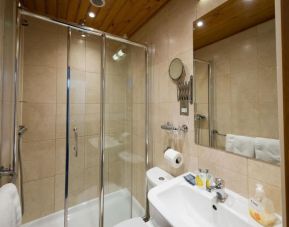 Private guest bathroom with shower and free toiletries at Adria Hotel.