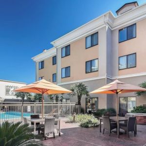 Outdoor seats available beside the pool at Courtyard Bossier City.