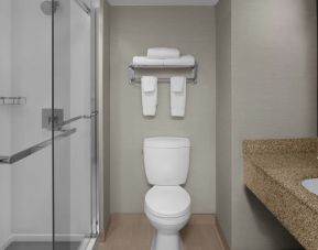 Guest bathroom with shower at Courtyard By Marriott Cypress Anaheim.