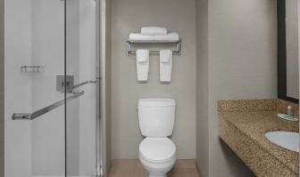 Guest bathroom with shower at Courtyard By Marriott Cypress Anaheim.