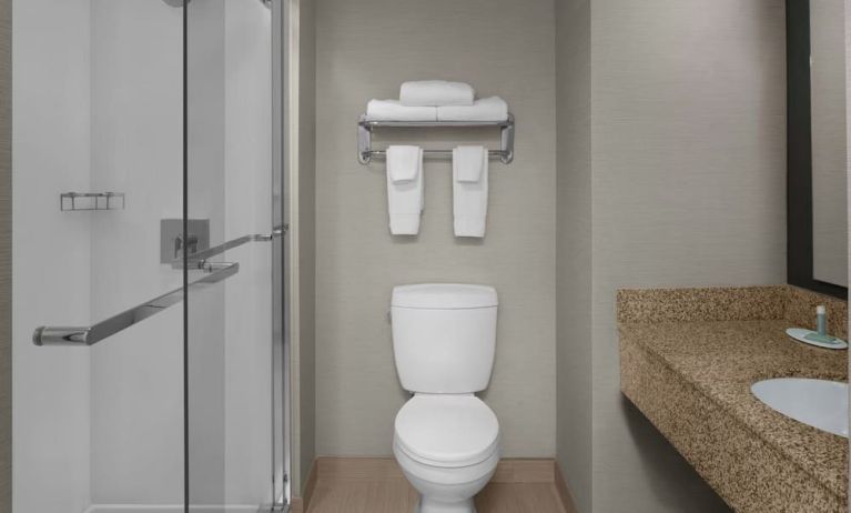 Guest bathroom with shower at Courtyard By Marriott Cypress Anaheim.