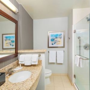 Guest bathroom with shower at Courtyard By Marriott Santa Ana Orange County.