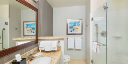 Guest bathroom with shower at Courtyard By Marriott Santa Ana Orange County.