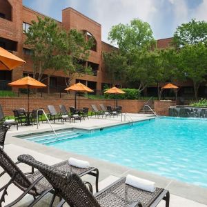 Refreshing outdoor pool with plenty of sun loungers at DoubleTree Suites By Hilton Hotel Charlotte - SouthPark.