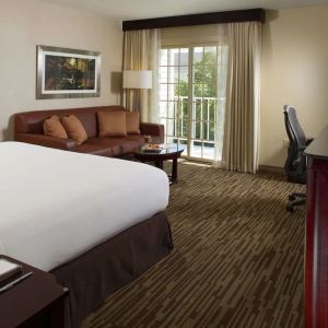 Day use room with sofa, work desk and balcony at DoubleTree Raleigh Durham Airport At Research Triangle Park.