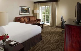 Day use room with sofa, work desk and balcony at DoubleTree Raleigh Durham Airport At Research Triangle Park.