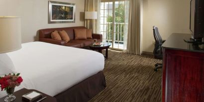 Day use room with sofa, work desk and balcony at DoubleTree Raleigh Durham Airport At Research Triangle Park.