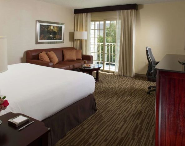 Day use room with sofa, work desk and balcony at DoubleTree Raleigh Durham Airport At Research Triangle Park.