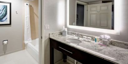 Guest bathroom with shower and tub at Homewood Suites By Hilton San Jose Airport-Silicon Valley.